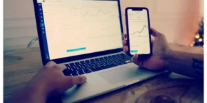 주식 초보자인 남성이 컴퓨터와 스마트폰으로 주식 차트를 확인하고 있는 모습