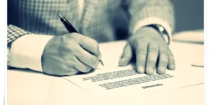 스마트 계약이 아닌 전통적인 계약 서류에 서명하는 모습