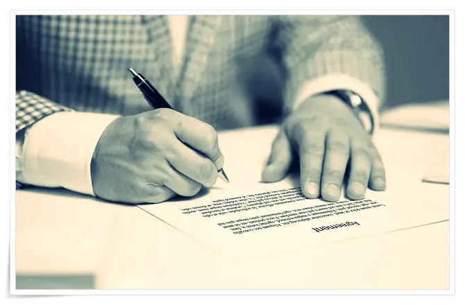 스마트 계약이 아닌 전통적인 계약 서류에 서명하는 모습